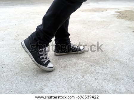 Legs go forward with Black Sneakers  Royalty-Free Stock Photo #696539422