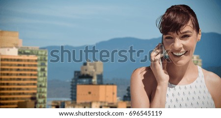 Businesswoman using cell phone against buildings in city against blue sky