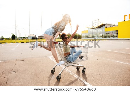Picture of young amazing women friends have fun with shopping trolleys.