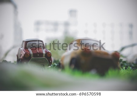 Closeup image of small vintage cars model on green grass