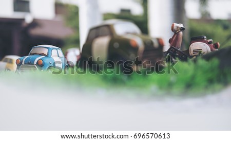 Closeup image of small vintage cars model on green grass