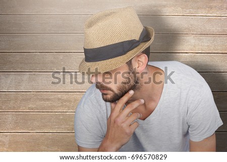 Handsome man wearing hat  against wooden surface with planks