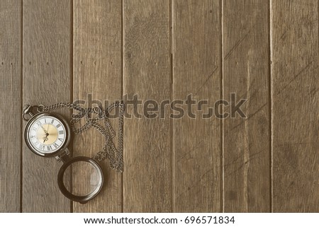 Vintage clock with chain on a background of old wooden planks with copy space.