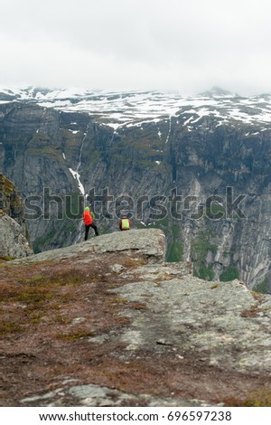 Couple sitting against amazing nature view on the way to Trolltunga. Location: Scandinavian Mountains, Norway, Stavanger. Artistic picture. Beauty world. The feeling of complete freedom