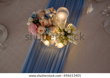 Wedding decorations. Fresh spring tulips and candles in glasses. Covered festive table. Bride idea. 