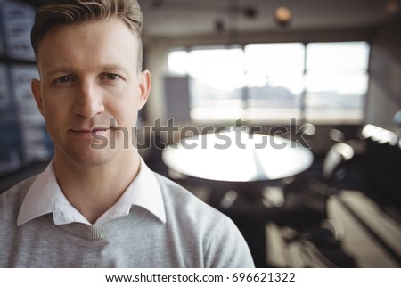 Digital composite of Business man standing against office background