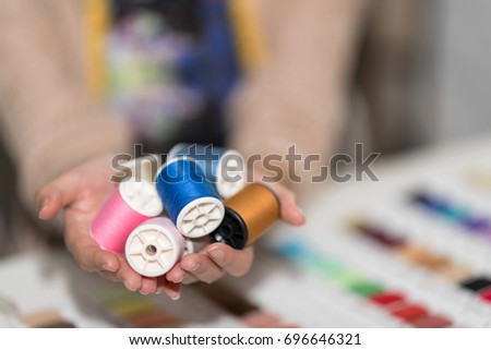 Seamstress or dressmaker with colorful buttons in a handful.needlework, craft, sewing and tailoring concept