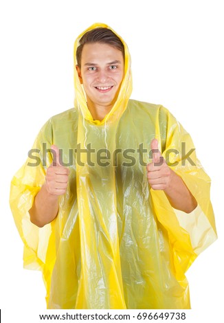 Picture of a young man wearing a yellow raincoat, showing thumbs up on isolated background