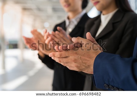 Three business people clap their hands to congratulate the signing of an agreement or contract between their firms, companies, enterprises. success, dealing, greeting and partner concept.