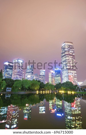 Of tall buildings in the center of the garden green space in the evening.