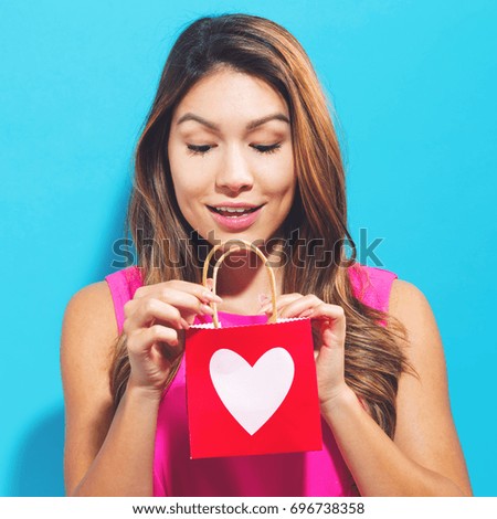 Happy woman with a gift bag with a heart print