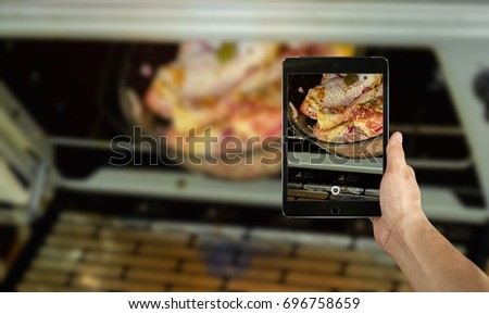 man taking a picture of raw chicken drumstick using a smartphone, point of view shot