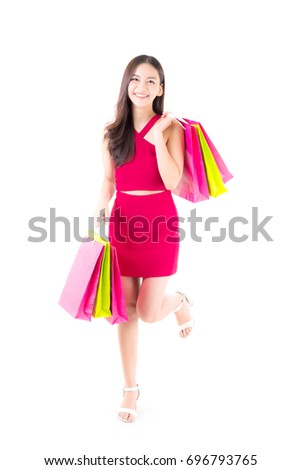 portrait of a happy excited asian woman in red dress standing and holding colorful shopping bags with happy isolated on a white background.