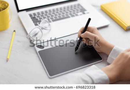 The professional photographer retouches photos on a notebook. Creative illustrator drawing website layout. Designer working with a graphic tablet. Digital art. UX/UI design.