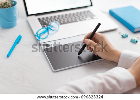 The professional photographer retouches photos on a notebook. Creative illustrator drawing website layout. Designer working with a graphic tablet. Digital art. UX/UI design.