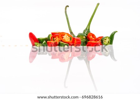 Isolated White Background - Green and Red Chilis Reflected. Abstract reflection. Shallow depth of field