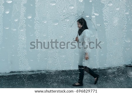 Woman in the rain with umbrella, girl putting up umbrella in raining that picture converted by add drop raining
