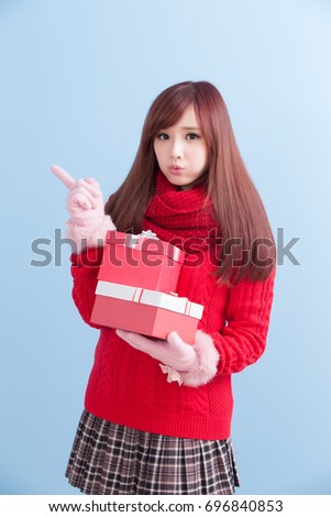 beauty woman take gift and show something  in christmas isolated on blue background, asian