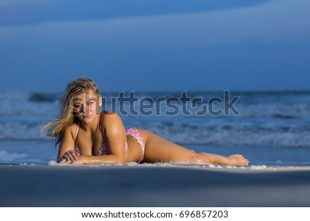 A beautiful blonde teenage model enjoys a day by the beach
