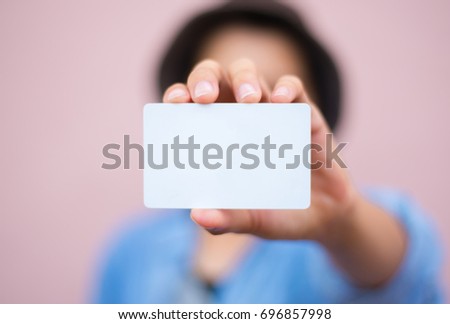 soft focus.hand man holding business card with empty space for text. on blurred pink pastel color background
