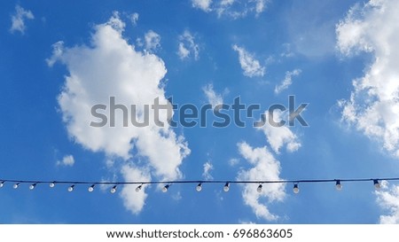 Light bulb under the blue sky with cloudy background