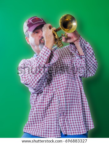 A man playing solo blues on a trumpet against a green background