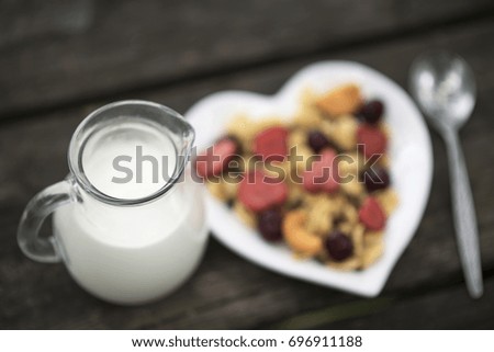 healthy Breakfast with fruits and berries on a plate in the shape of heart . Fresh strawberries on a plate in the shape of heart . milk