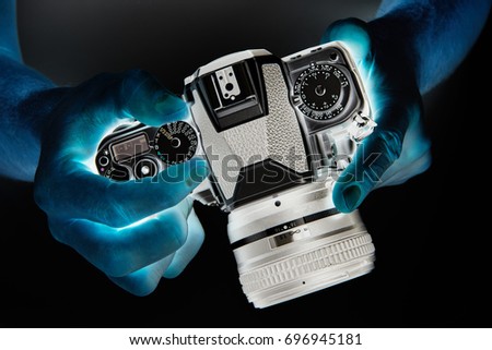 Negative photo of SLR camera in the hands of the photographer closeup