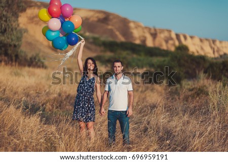 The couple in love for a walk in nature with baloons