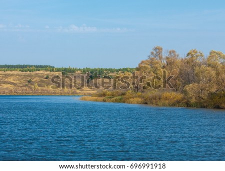 fall river. Autumn colorful foliage over lake with beautiful woods in red and yellow color. Autumn landscape with a river. Beautiful autumnal scene, fall