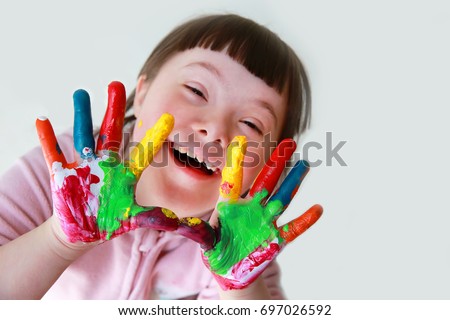 Cute little down syndrome girl with painted hands. Royalty-Free Stock Photo #697026592