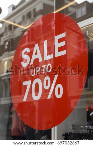 Sale up to 70 percent red sign. Red circle with sale up to seventy percent inscription sticked on the store window
