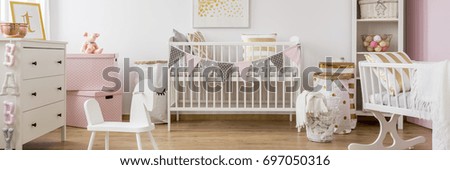 Gold and pink baby room with white wooden furniture