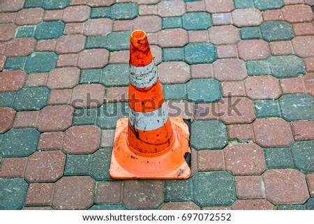 Plastic striped orange road sign in the form of a cone