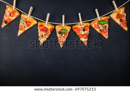 Pieces of pizza in the form of a garland of flags on a dark background. Pizza menu. Conceptual space for text. Billet for the poster of pizzeria.
