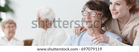 Helpful volunteer taking care of senior lady at healthcare home Royalty-Free Stock Photo #697079119