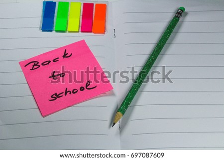 Sign Back to school` on exercise book This is notice Back to school on white exercise book with school aids.