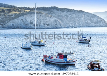 Mediterranean marina at cliff backgound. Skyline seascape scenery. Blue toned picture.