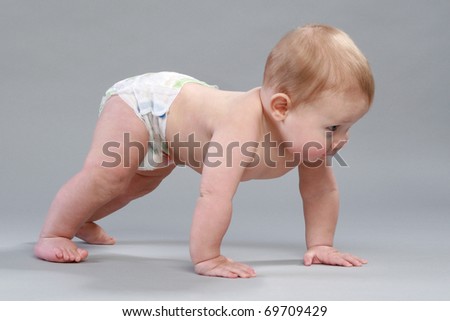 Little boy in pampers crawling on gray background Royalty-Free Stock Photo #69709429
