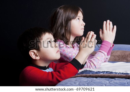 A brother and sister say their prayers just before bedtime. Royalty-Free Stock Photo #69709621