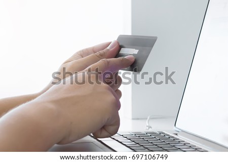 Businessman doing online shopping Hand holding credit card and using laptop and check number "CVV" card. Online shopping concept. Closeup hand Royalty-Free Stock Photo #697106749