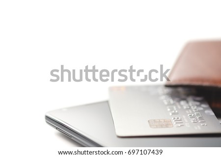 Credit cards on smartphone and brown leather wallet with shallow focus and copy space, toned picture