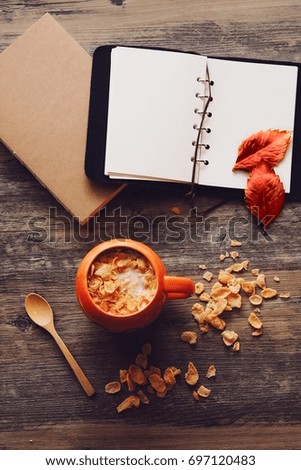 Top view of Coffee cup and paper notebook on wooden table background,copy space in concept color of autumn.
