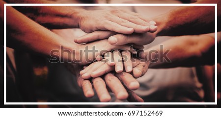 Happy volunteer family putting their hands together on a sunny day Royalty-Free Stock Photo #697152469