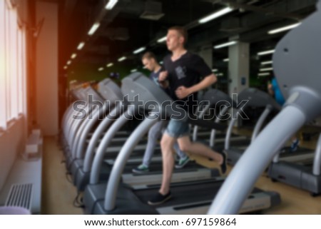 Row of treadmills in modern fitness center. Blurred picture of Running people. Gym equipment.