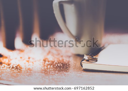 ring on the notebook with a cup of beverage for background feeling alone or think of memory concept