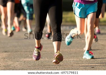 Adults legs racing a 5K at a New York State Park in the early evening over the summer. Royalty-Free Stock Photo #697179811