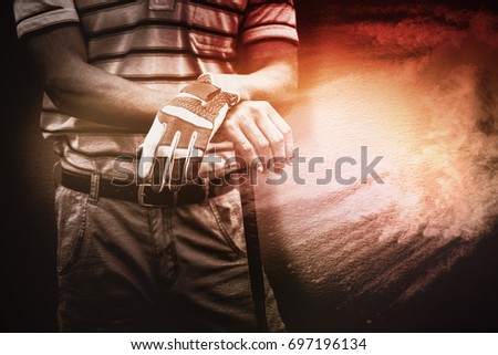 Man holding a golf club against beige background texture
