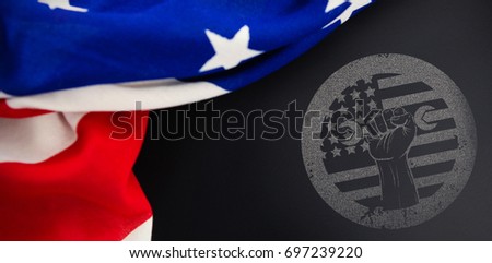 Cropped hand holding tool and american flag on red poster against american flag on empty slate