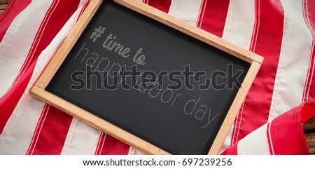 Digital composite image of time to happy labor day text against american flag with slate on wooden table